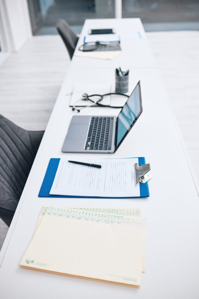 Health, office and checklist with laptop on table in hospital for survey, information and insurance