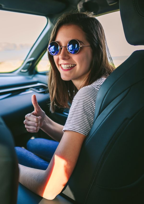 Girl doing thumbs up in the car