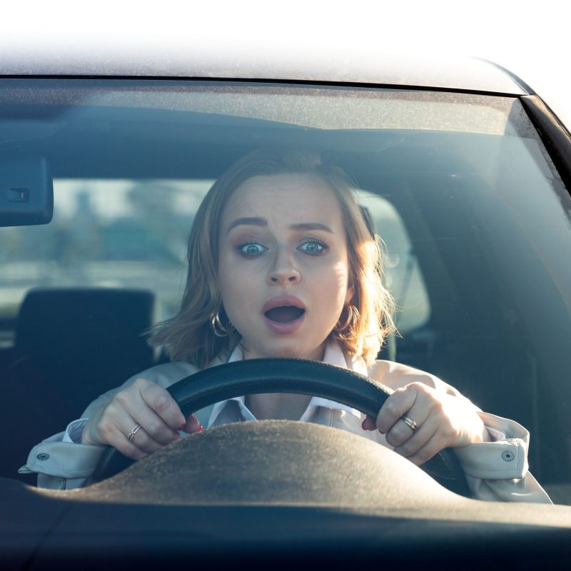 Frau schaut fragen über das Lenkrad