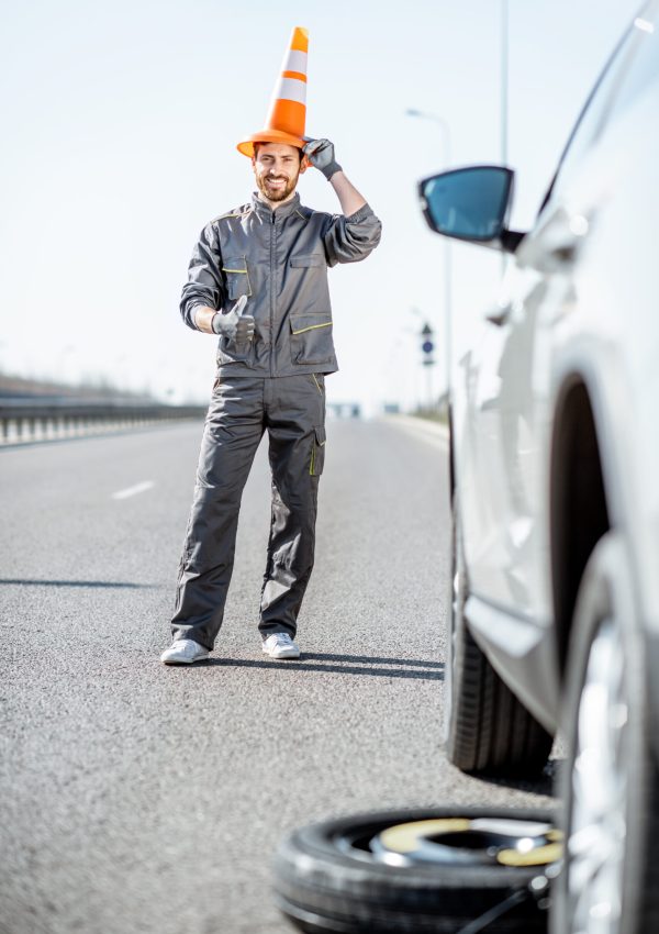 Arbeiter mit Fahrbahnkegel auf der Autobahn